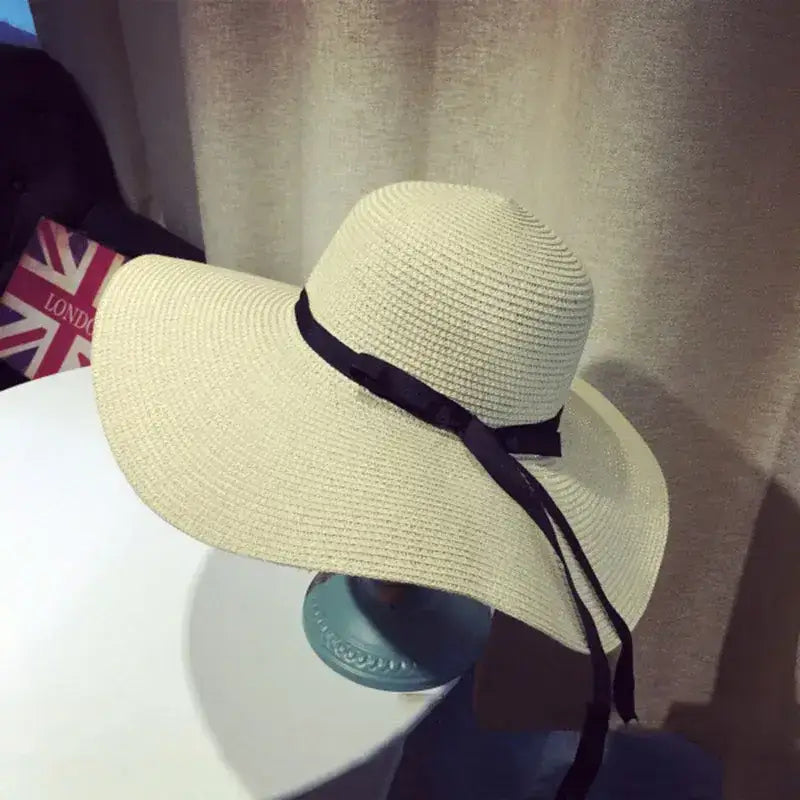 Wide brim floppy hat for women with a stylish black ribbon detail, perfect for sunny days