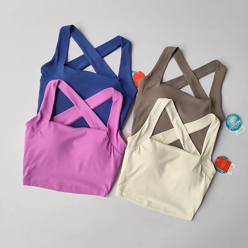 Assorted beauty back yoga bras in blue, pink, brown, and cream with cross-back design