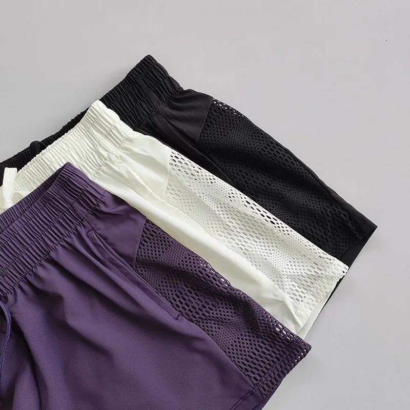 Breathable gym shorts for women in purple, white, and black with mesh detailing for comfort