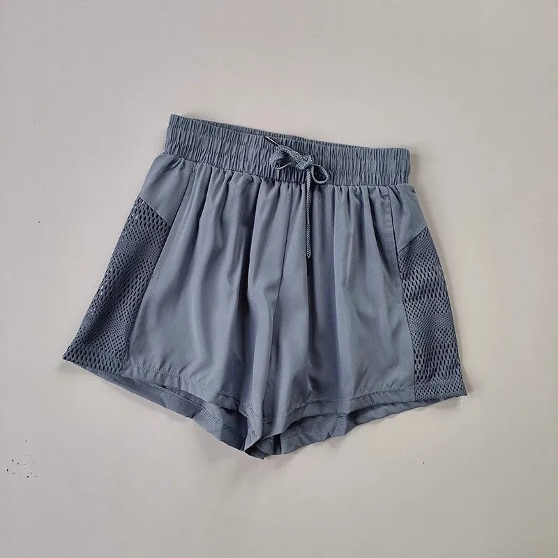 Light gray breathable gym shorts for women with mesh side panels and drawstring waist