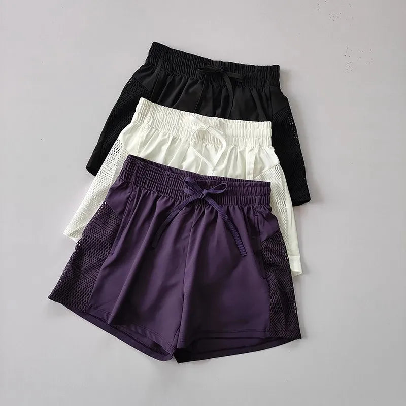 Breathable gym shorts for women in black, white, and purple with mesh side panels and drawstring waist