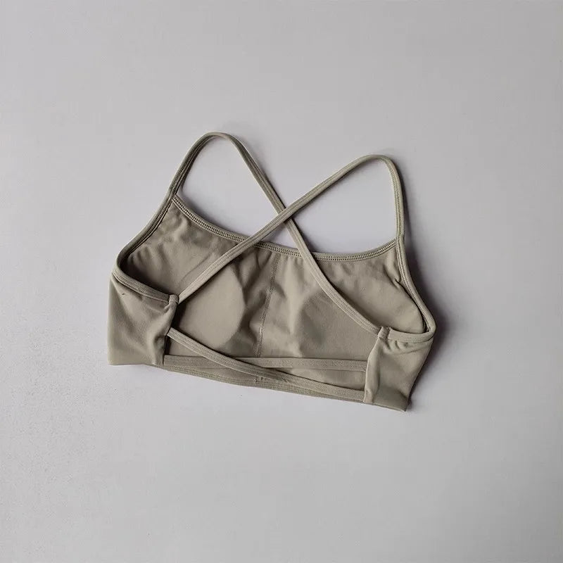 Beige cross back sports bra designed for comfort and support during workouts