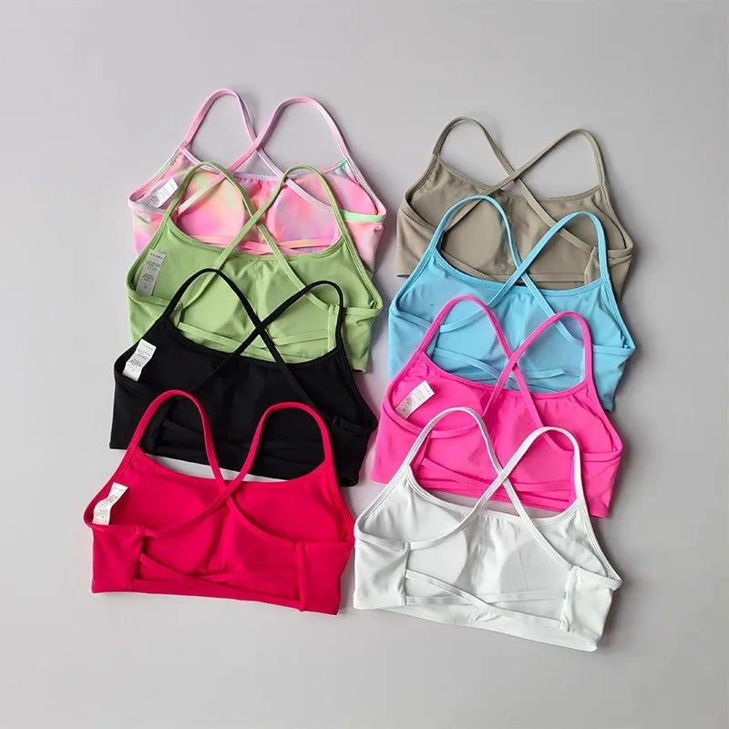 Colorful assortment of cross back sports bras in various shades for comfortable activewear