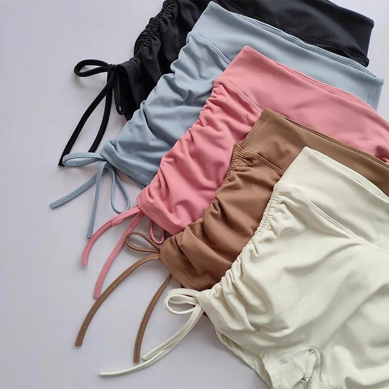 Colorful ladies high waist workout shorts with drawstring details in various shades folded neatly