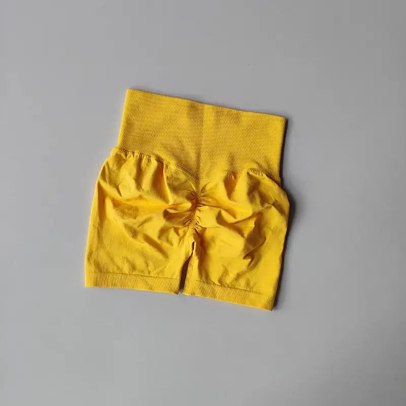 Yellow push-up gym shorts for women with gathered back design for a flattering fit