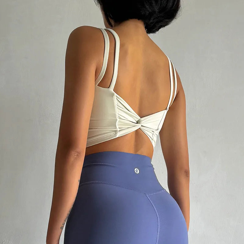 Beige push up sports bras for women featuring a stylish back twist design and adjustable straps