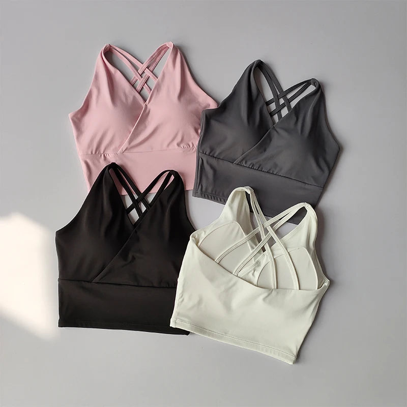 Collection of shockproof crop tops for women in pink, black, gray, and white with stylish cross-back design