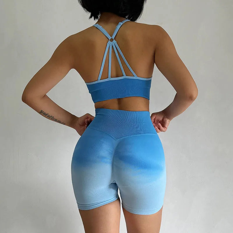 Back view of a blue two piece athletic wear set for women featuring a crop top and high-waisted shorts