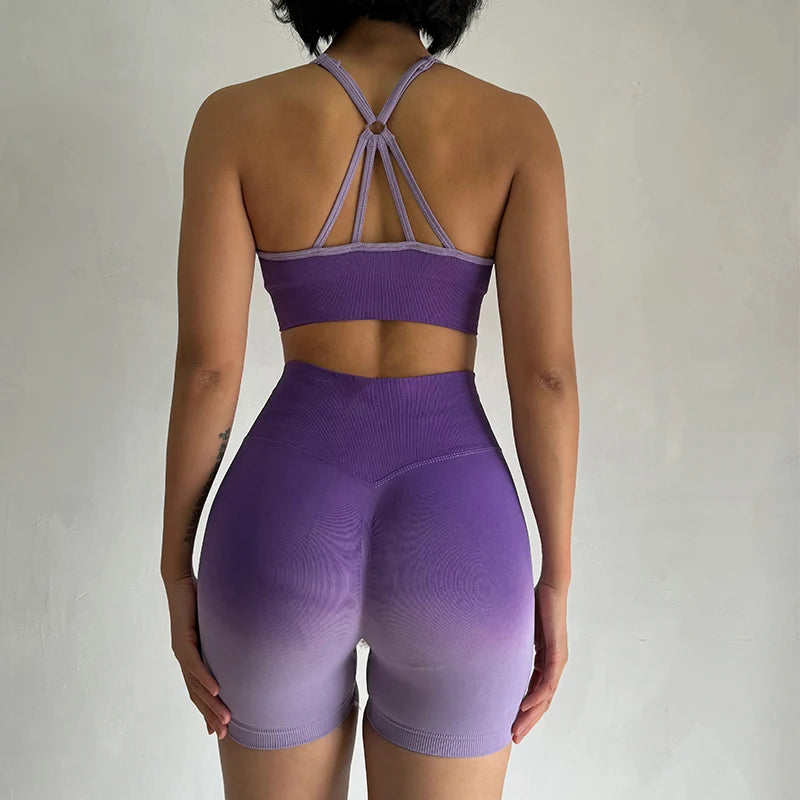 Back view of two piece athletic wear set for women in purple with stylish straps and high-waisted shorts