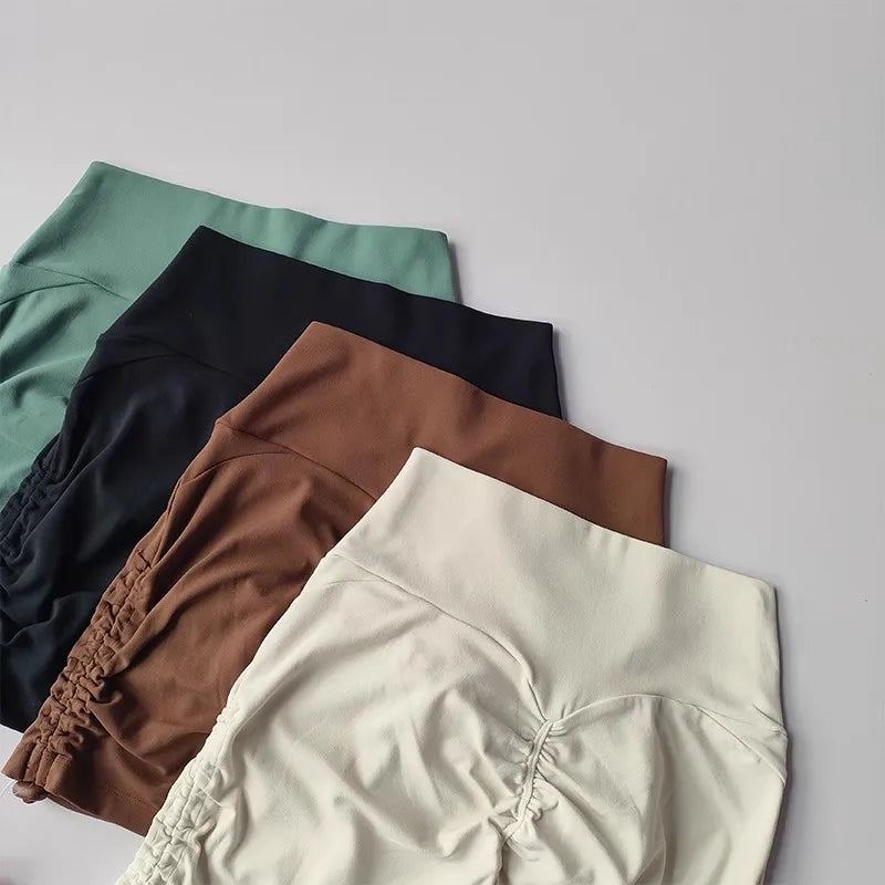 Assorted drawstring sports shorts for women in green, black, brown, and cream colors
