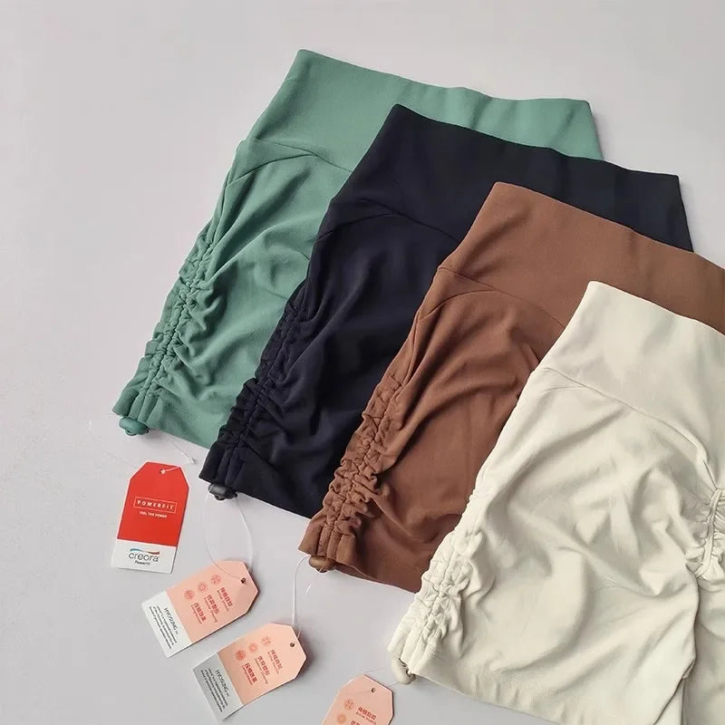 Four pairs of drawstring sports shorts for women in green, navy, brown, and beige colors