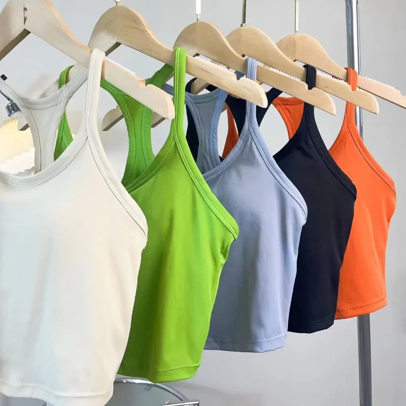 Colorful collection of womens push up sports bras hanging on wooden hangers in various shades